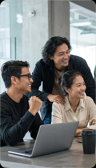 Mooselab teammates celebrating a win together around a laptop